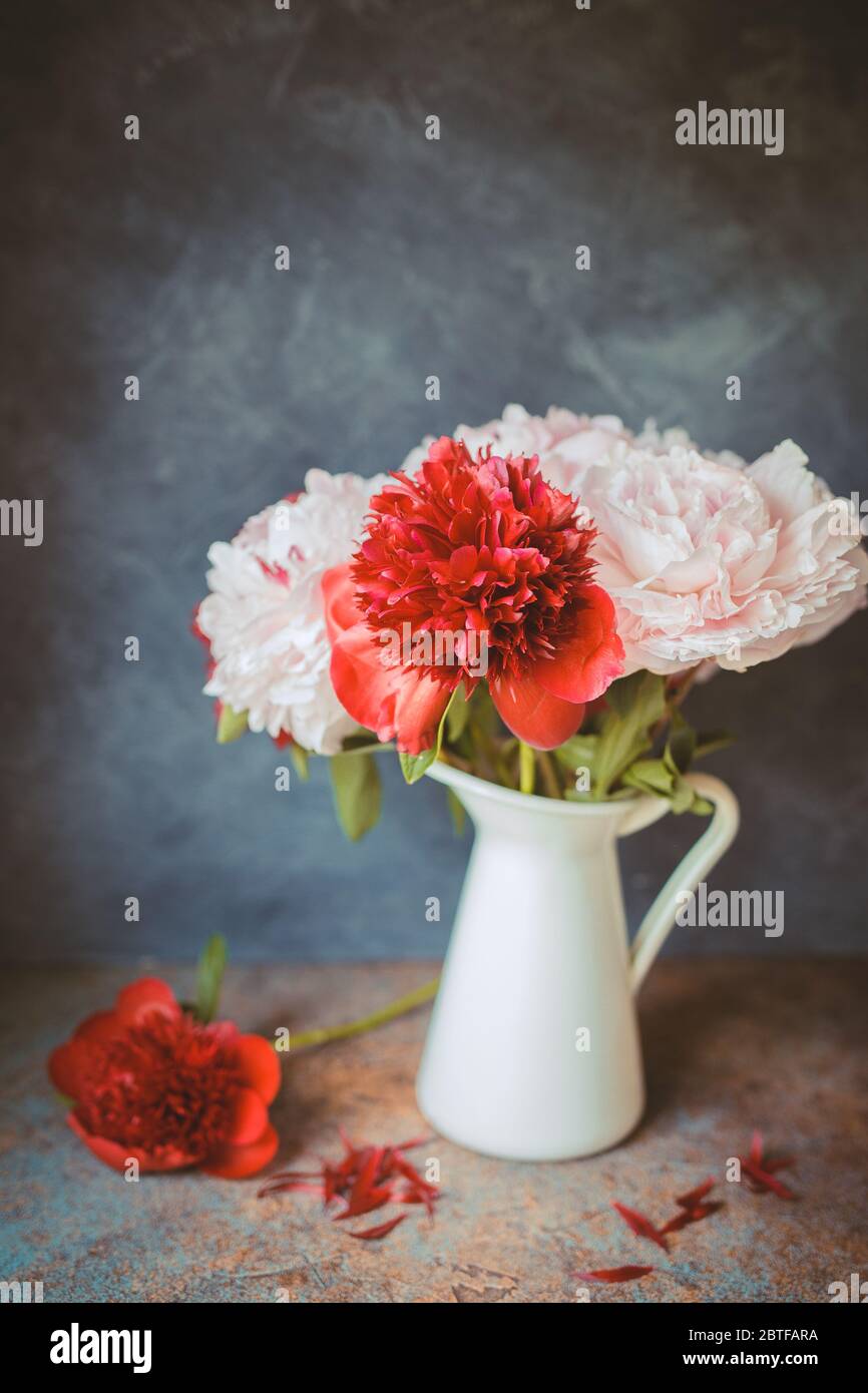 Foto mit Ton. Vase mit Bouquet von schönen Pfingstrosen auf dem Tisch im Zimmer, Nahaufnahme. Blüte. Pfingstrose. Stockfoto