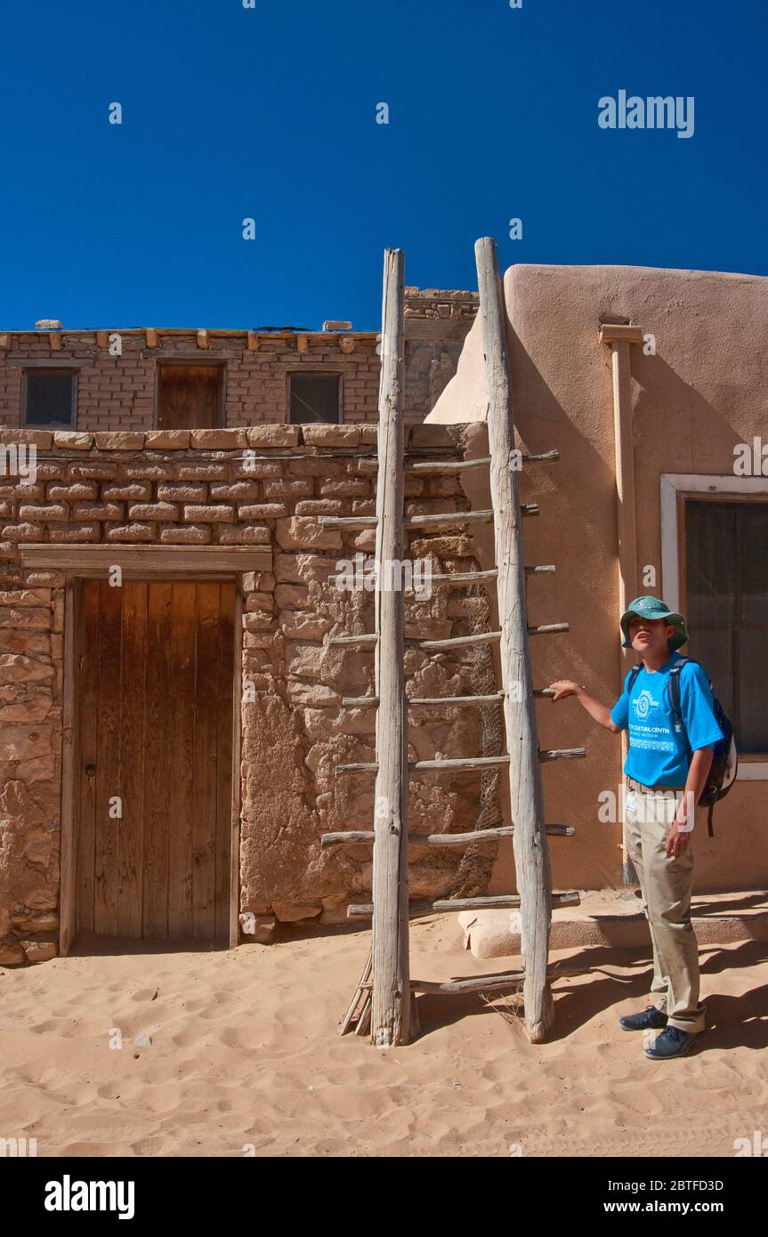 Lokaler Guide an der Holzleiter in der Wohnung in Acoma Pueblo (Sky City), Indianerpueblo auf mesa in Acoma Indianerreservat, New Mexico USA Stockfoto