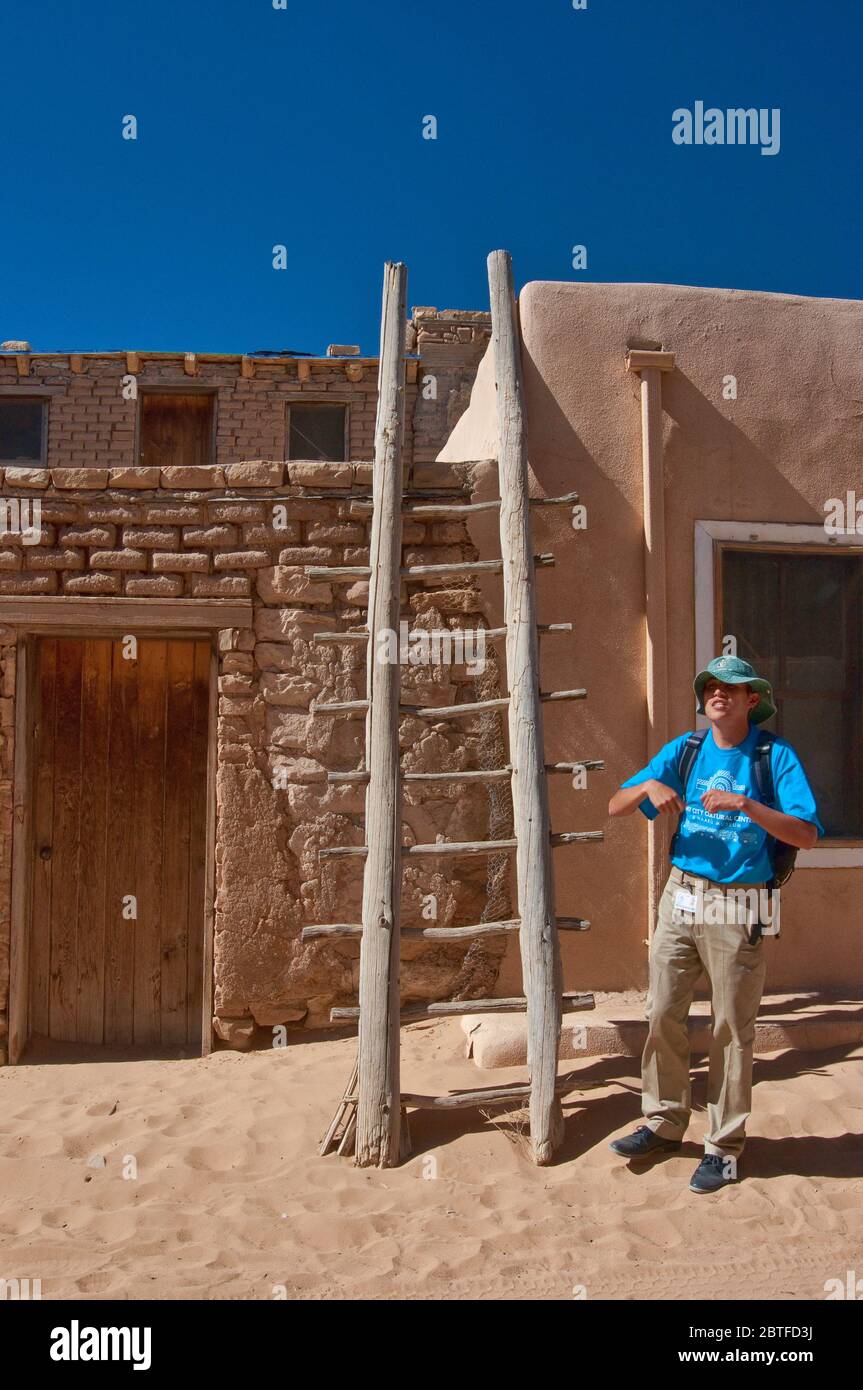 Lokaler Guide an der Holzleiter in der Wohnung in Acoma Pueblo (Sky City), Indianerpueblo auf mesa in Acoma Indianerreservat, New Mexico USA Stockfoto