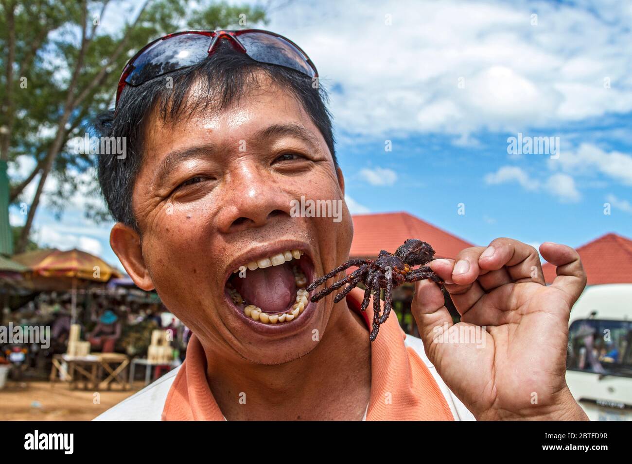 Der Kambodschaner macht sich bereit, eine gebratene Tarantula zu essen. Panierte und frittierte Tarantulas sind in Skuon, Kambodscha, bekannt als 'Spiderville', erhältlich. Stockfoto