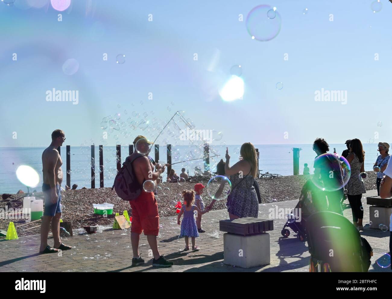 Brighton UK 25. Mai 2020 - EIN Bubble Entertainer in der späten Nachmittagssonne am Strand und am Meer von Brighton, während das Feiertagswochenende heute an der Südküste während der Coronavirus COVID-19 Pandemie-Krise zu Ende geht. Quelle: Simon Dack / Alamy Live News Stockfoto