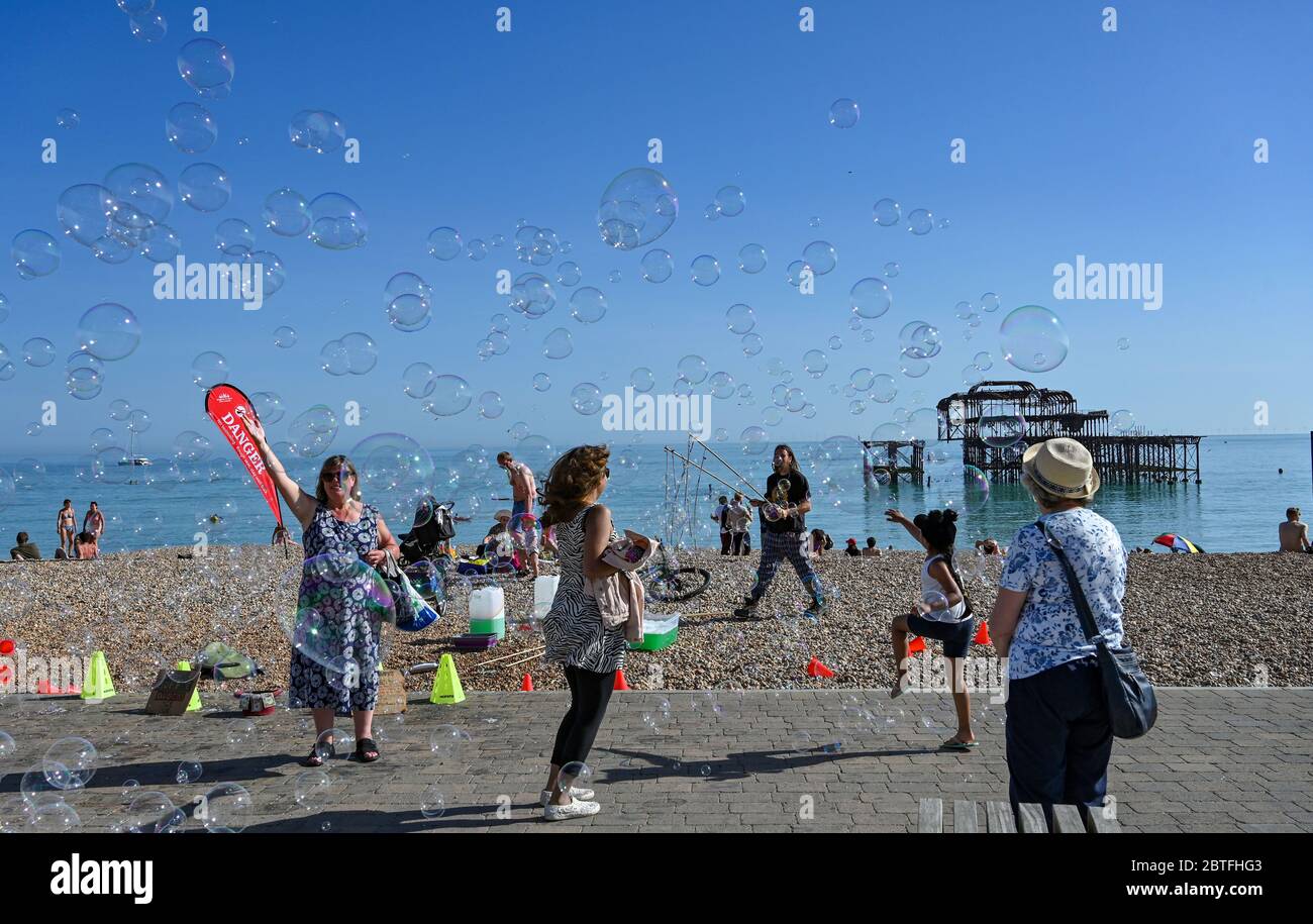 Brighton UK 25. Mai 2020 - EIN Bubble Entertainer in der späten Nachmittagssonne am Strand und am Meer von Brighton, während das Feiertagswochenende heute an der Südküste während der Coronavirus COVID-19 Pandemie-Krise zu Ende geht. Quelle: Simon Dack / Alamy Live News Stockfoto