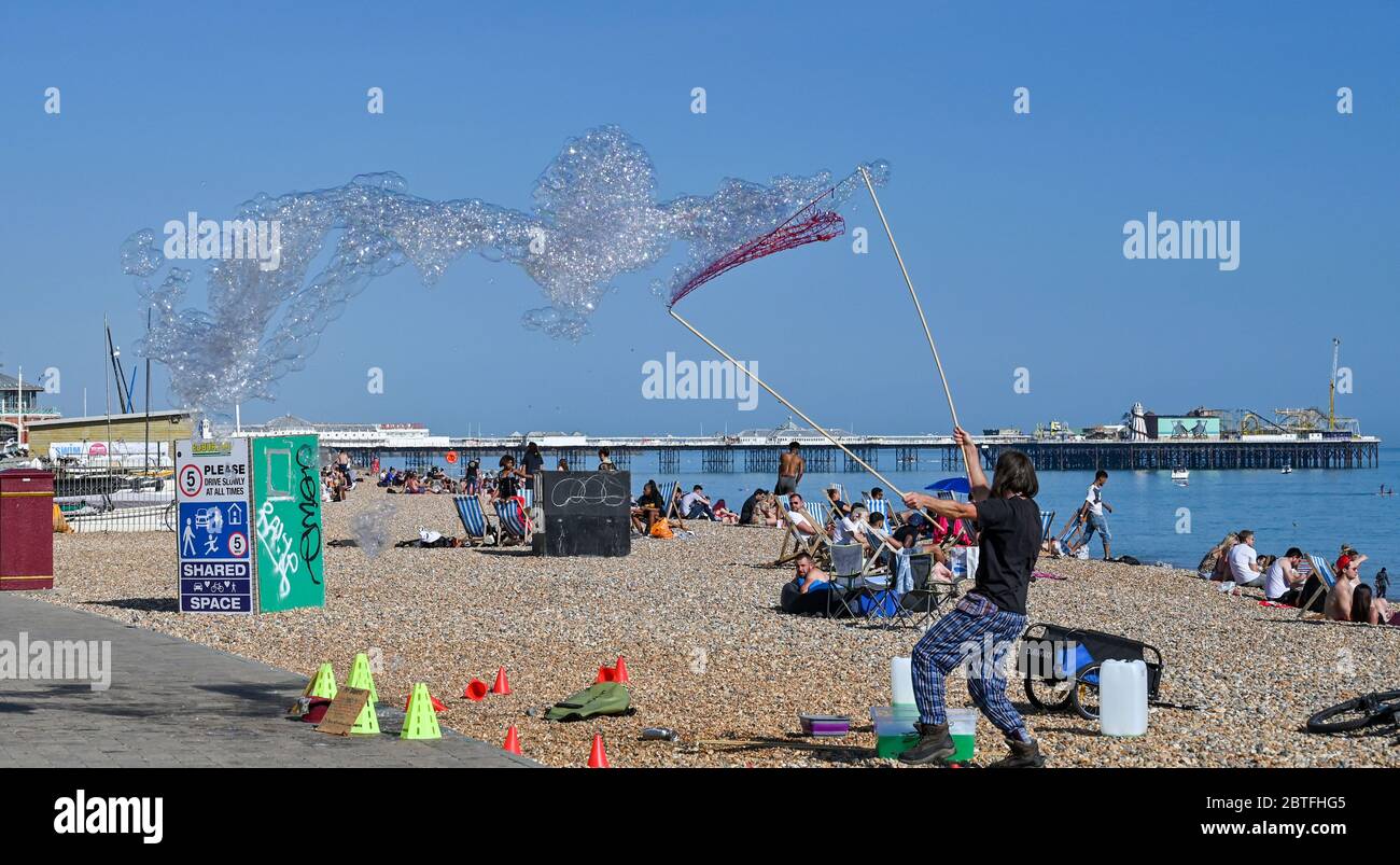 Brighton UK 25. Mai 2020 - EIN Bubble Entertainer in der späten Nachmittagssonne am Strand und am Meer von Brighton, während das Feiertagswochenende heute an der Südküste während der Coronavirus COVID-19 Pandemie-Krise zu Ende geht. Quelle: Simon Dack / Alamy Live News Stockfoto
