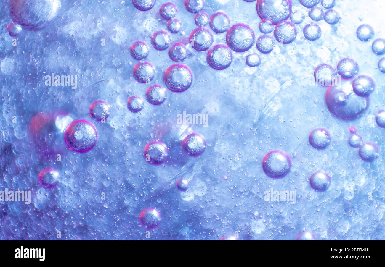 Wassertropfen auf lila Hintergrund. Farbige abstrakte Hintergrund. Stockfoto