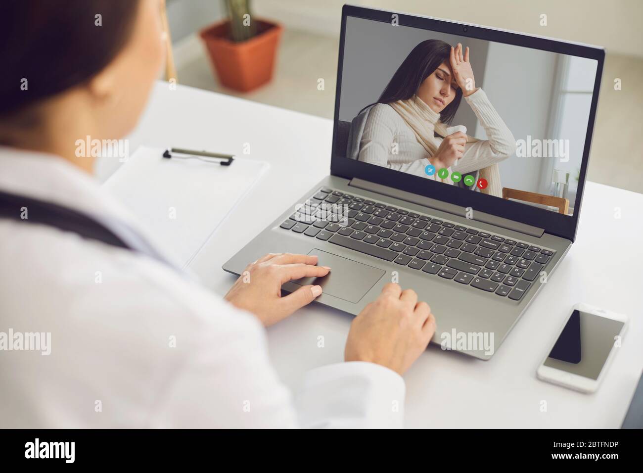 Online-Arzt. Der Arzt diagnostiziert einen Virusanruf eines Patienten online mit einem Laptop, der in einer Klinik sitzt. Virtuelle medizinische Hilfe. Stockfoto