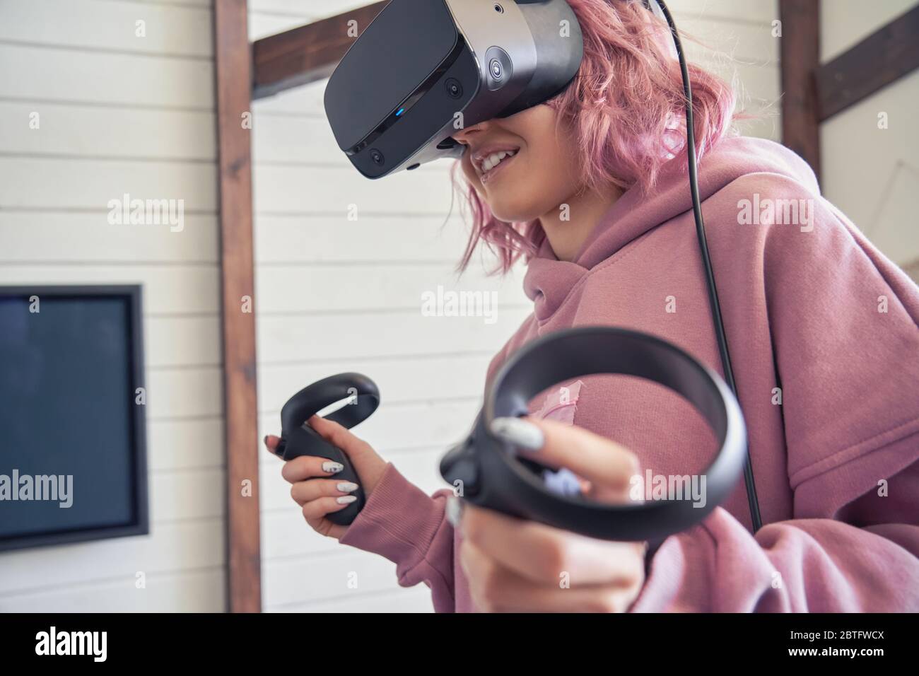Hipster teen Mädchen tragen vr Headset halten Controller spielen Virtual Reality-Spiel. Stockfoto