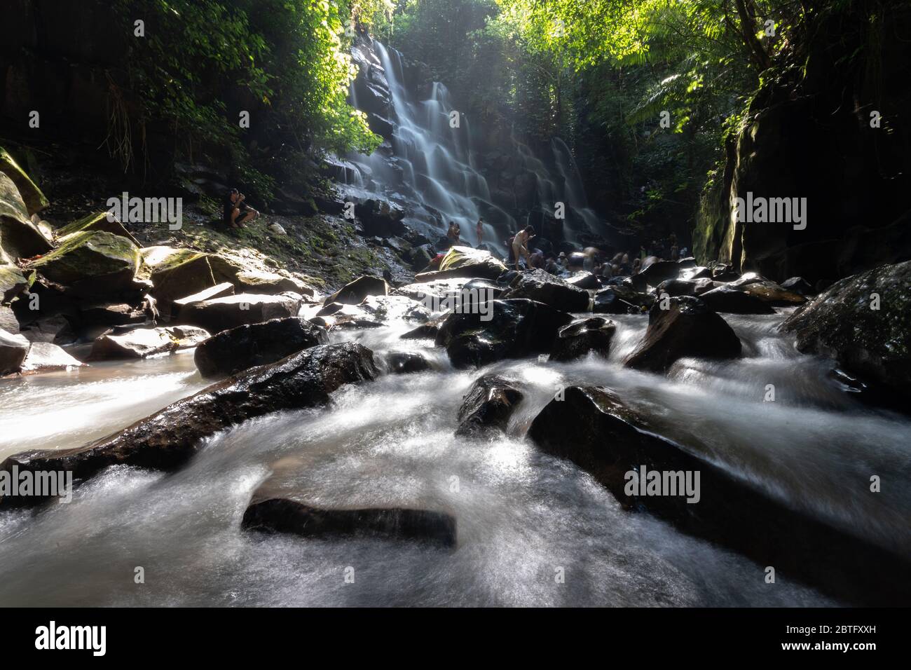 Wunderschöne Szene mit Wasserfall und Sonne, die durch die Bäume in bali indonesien scheint Stockfoto