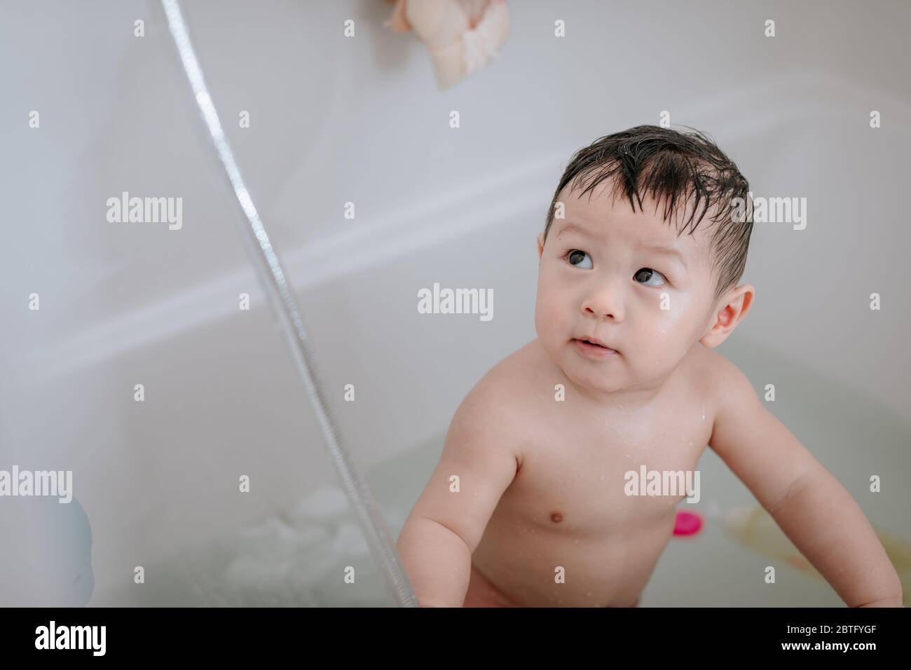 Kleiner Junge, der zu Hause in der Badewanne spielt Stockfoto