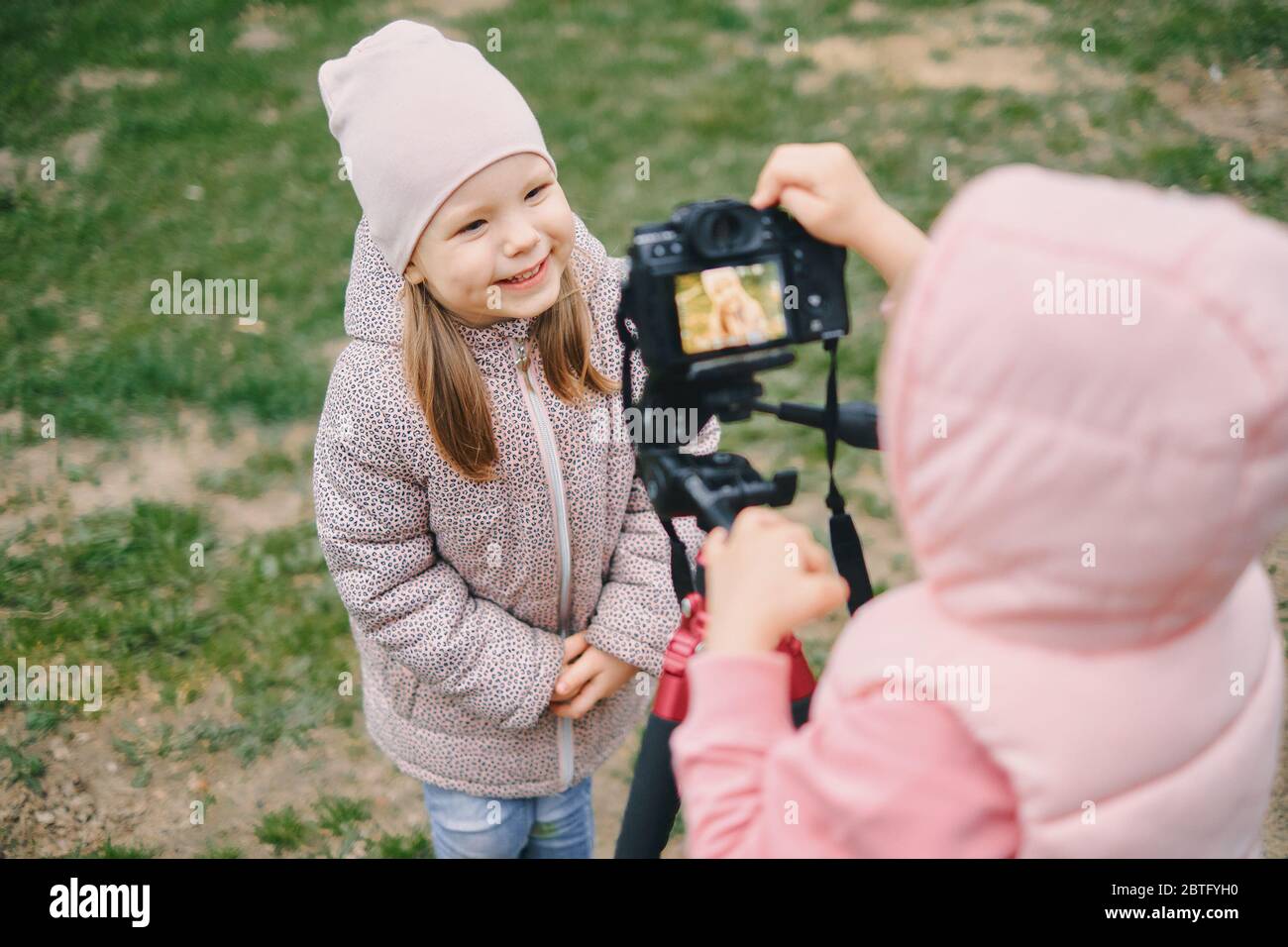 Kinder mit Fotoapparat in einem Stadtpark. Zwei Mädchen machen ein Video und Foto für das Internet, nehmen Sie ein Video-Blog für Kamera. Stockfoto