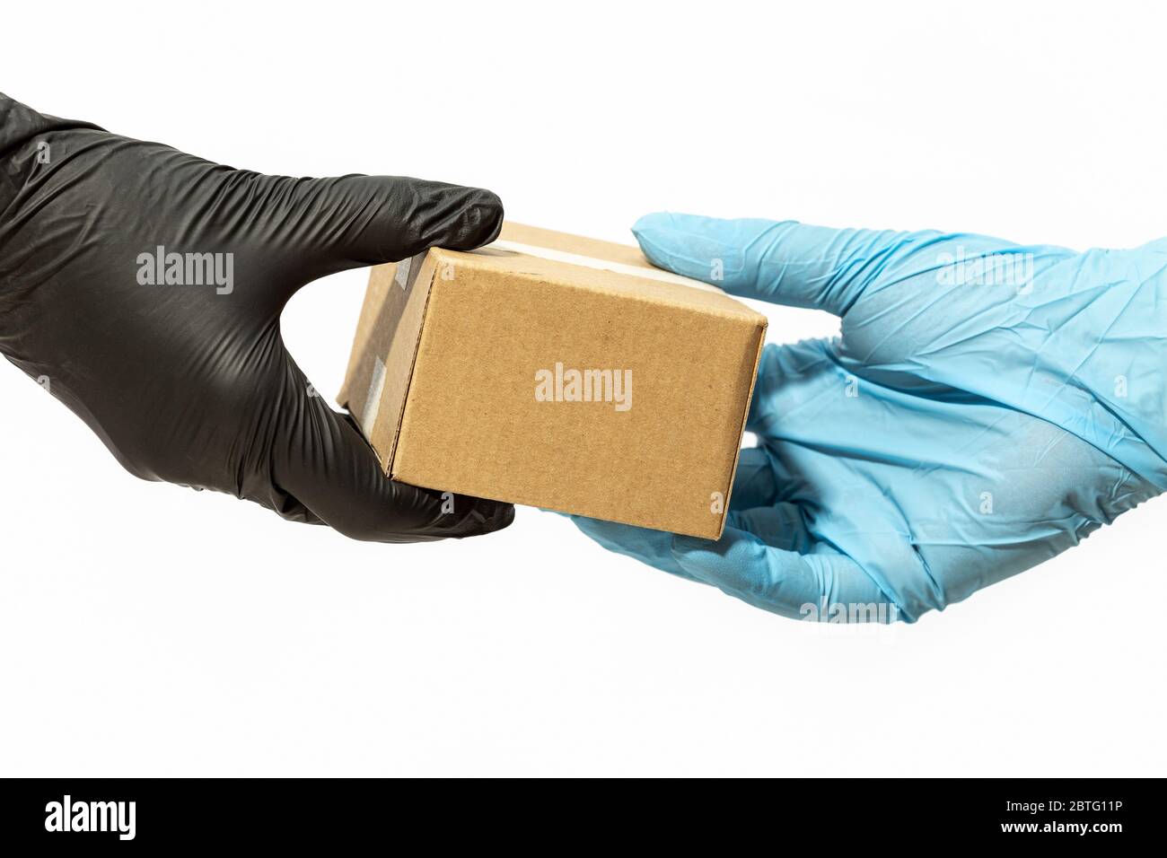 Kurier Mann Hand in schützenden Handschuh liefert ein Paket an einen Kunden oder Online-Käufer. Lieferung nach Hause während der COVID-19-Pandemie des Coronavirus Stockfoto
