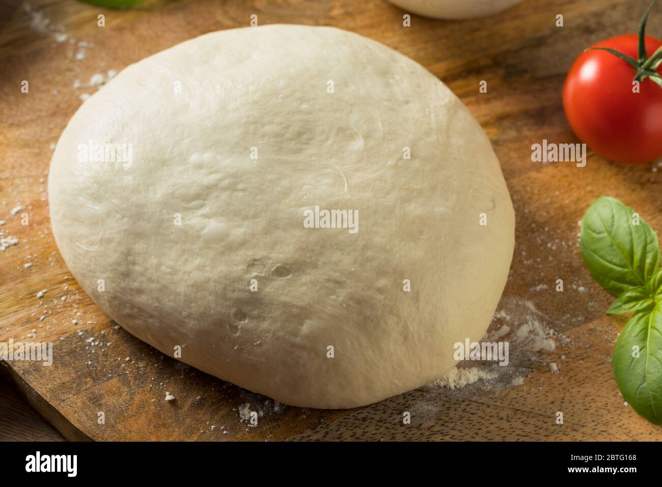 Hausgemachte Pizzateig und Zutaten mit Basilikum Stockfoto