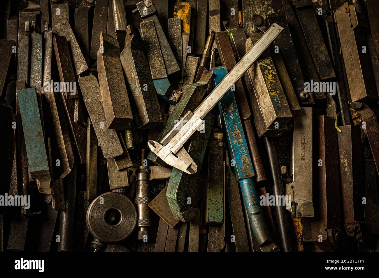 Rostende Stahlwerkzeuge und Bremssattel auf dem Tisch in der Metallfabrik Stockfoto