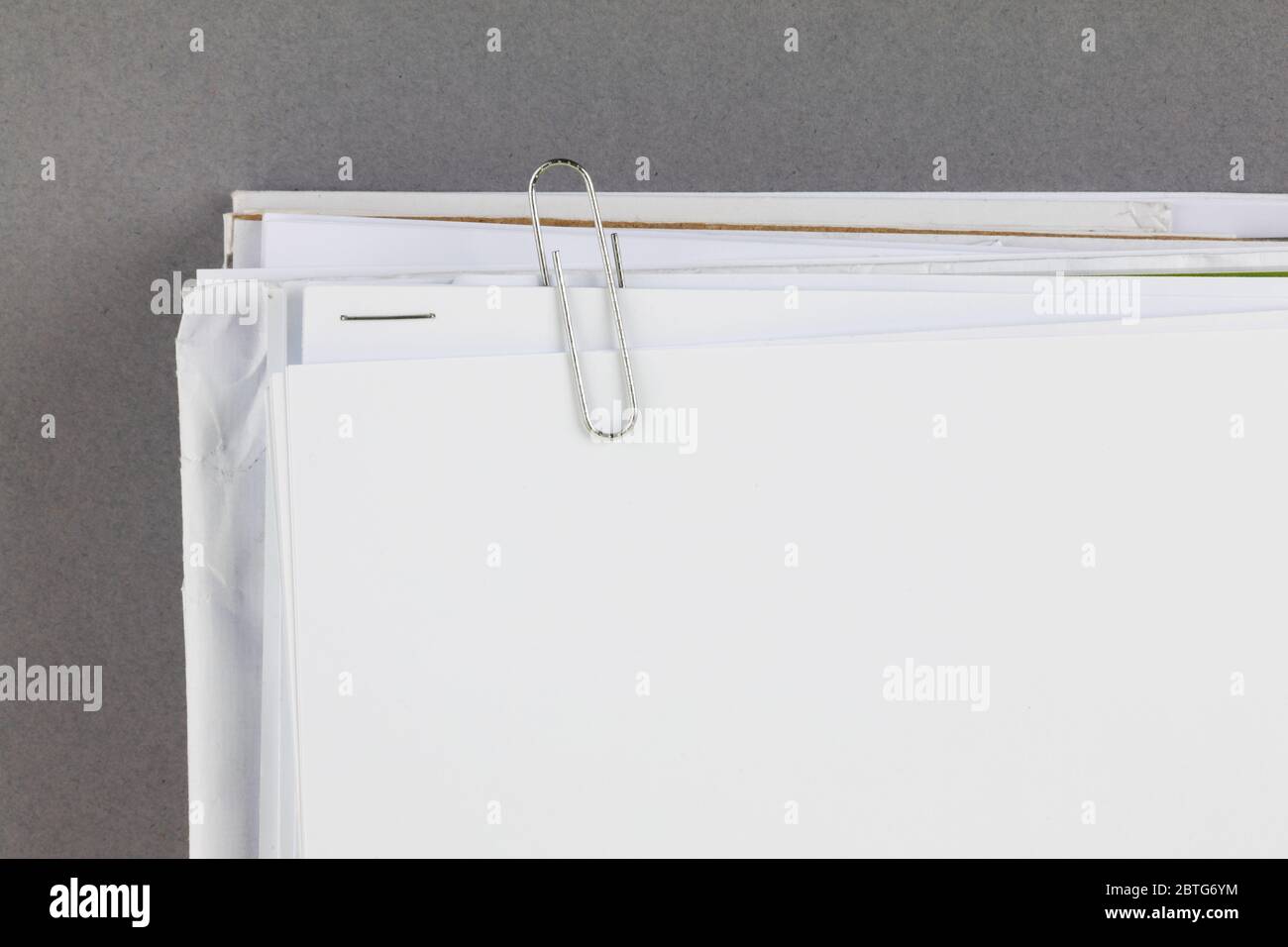 Bündel von Arbeitspapieren mit Büroklammer auf grauem Hintergrund Stockfoto