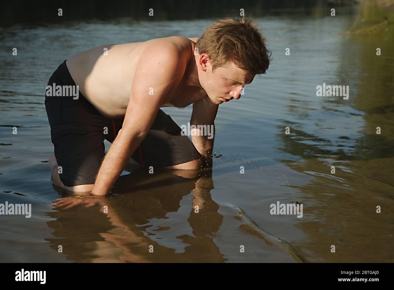 Guy Beobachtung Muschel Squitting Wasser Stockfoto