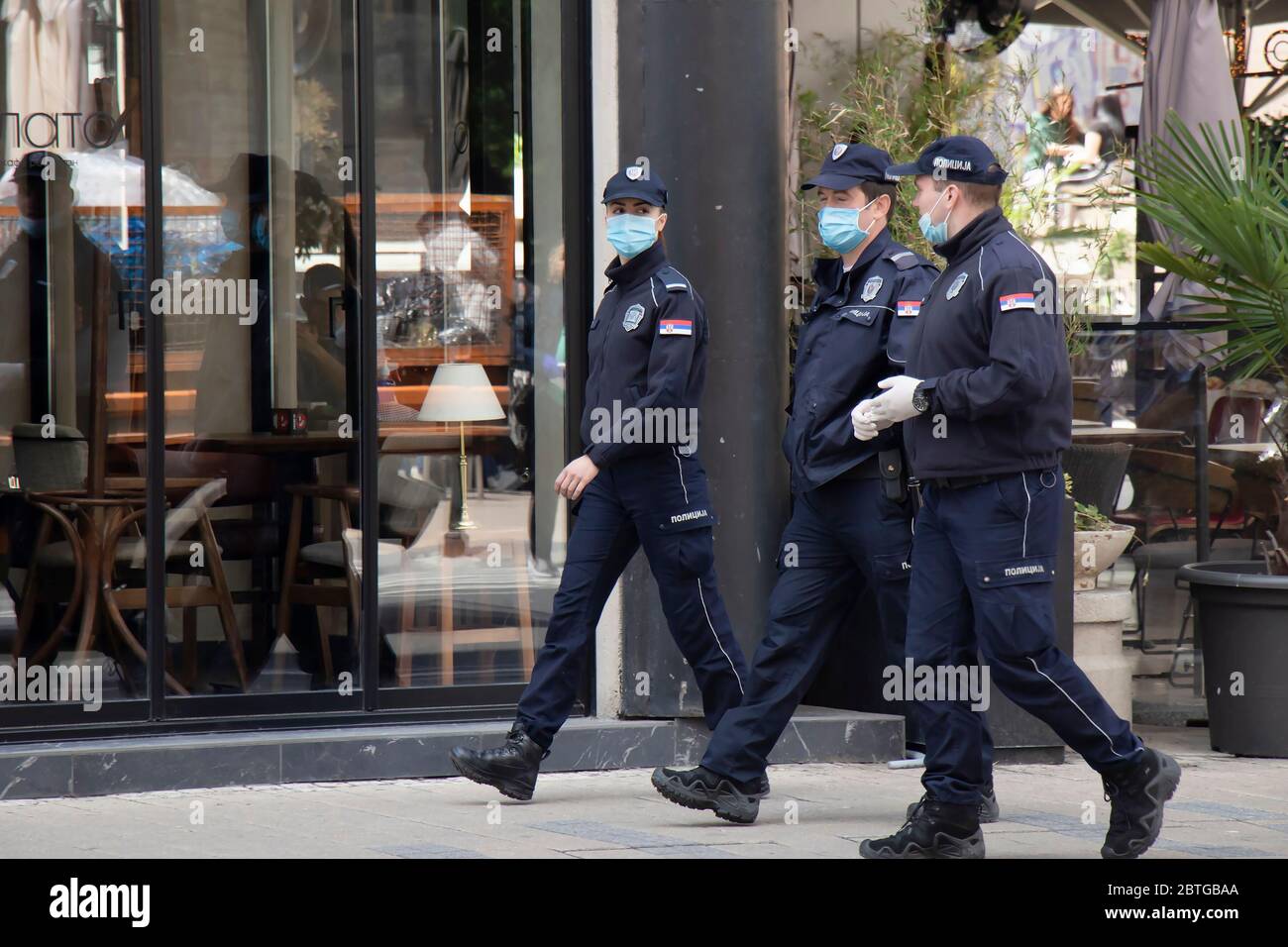 Belgrad, Serbien - 21. Mai 2020: Polizistin und Polizisten im Dienst, die chirurgische Gesichtsmasken tragen, während sie die Straßen der Stadt gehen und sprechen Stockfoto