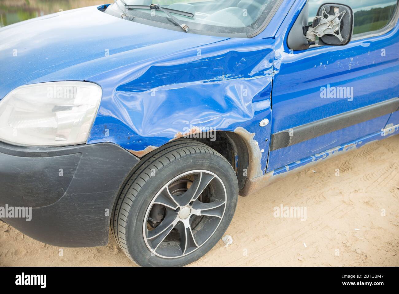Beschädigter Kotflügel des blauen Autos. Autounfall mit defekten Spiegel und Kotflügel Stockfoto