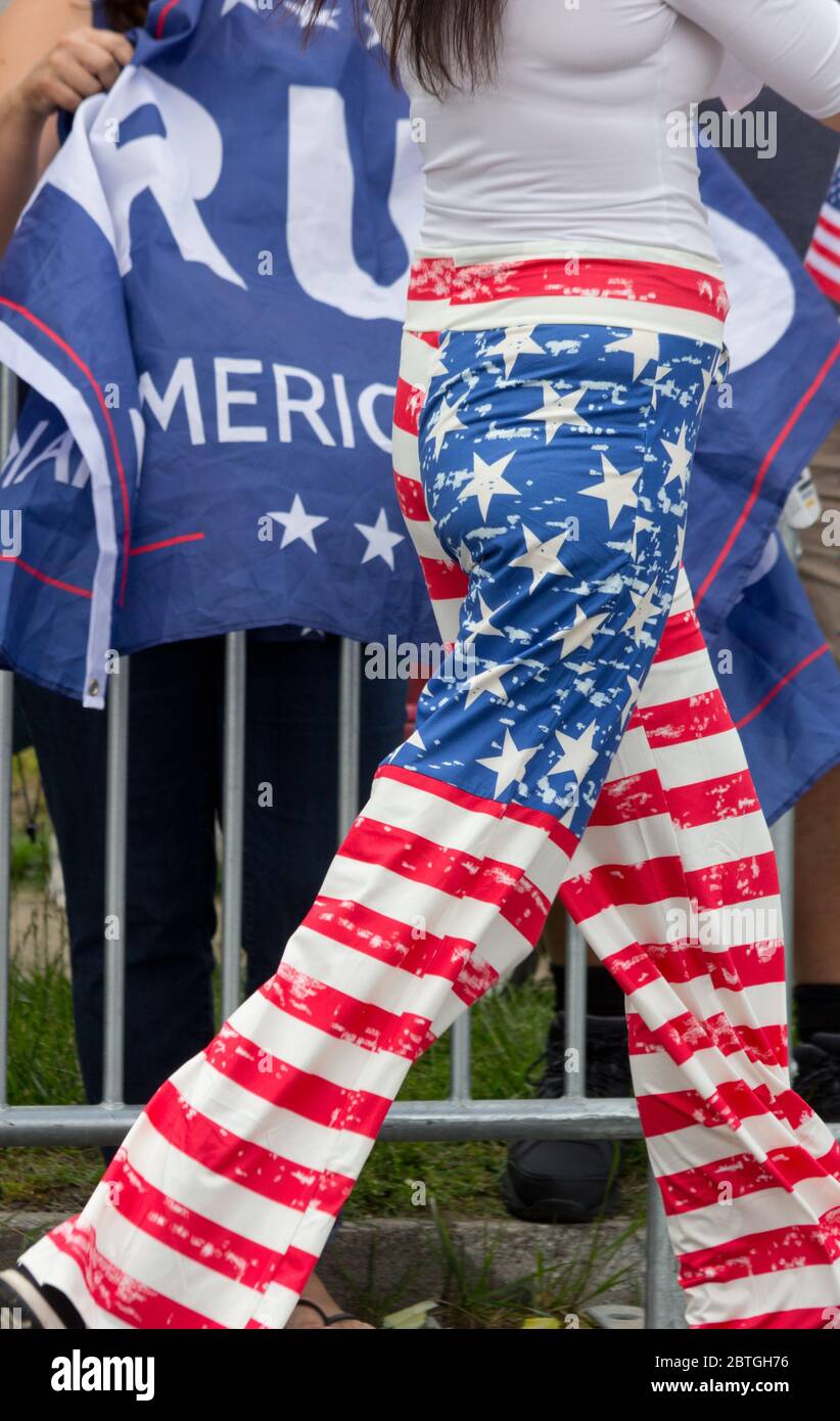 Baltimore, Maryland, USA. Mai 2020. Taille-Ansicht der Frau in amerikanischen Flagge-Design Hosen, wie sie durch einzelne hinter Barrikaden schreitet mit rumpeligen pro-Trump Banner, außerhalb des historischen Fort McHenry in Baltimore, Maryland; Wo Präsident Donald Trump und First Lady Melania Trump am Memorial Day 2020 besuchen, obwohl er vom Bürgermeister von Baltimore, Bernard C. „Jack“ Young, aufgefordert wird, abzusagen, um ein schlechtes Beispiel zu vermeiden, während die Stadt unter einer Aufenthaltsordnung bleibt (mit Ausnahmen, einschließlich einiger Outdoor-Übungen). Kay Howell/Alamy Live News Stockfoto