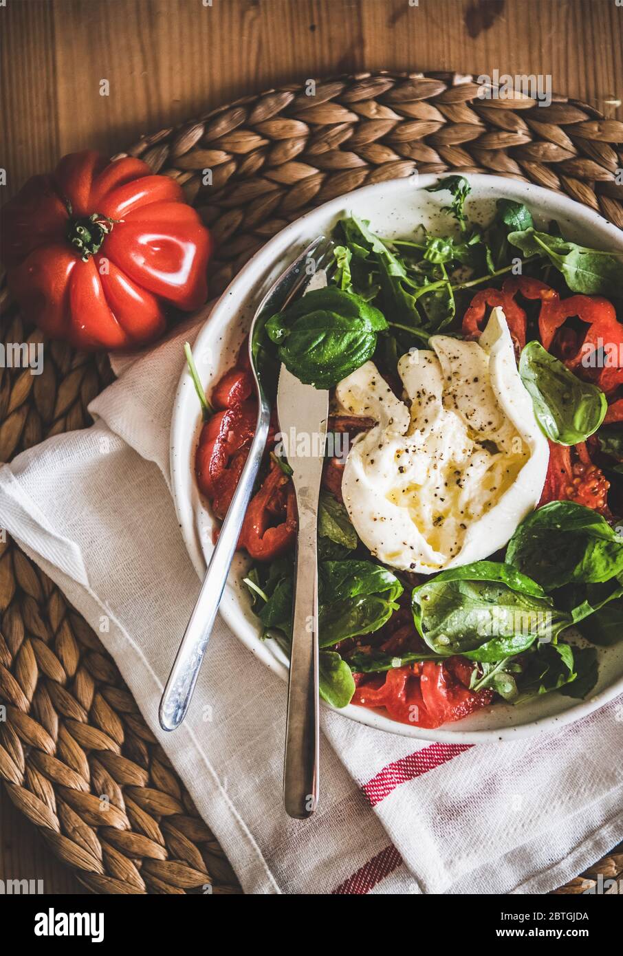 Italienischer Salat mit Buratta-Käse, Tomaten, Rucola und frischem Basilikum Stockfoto