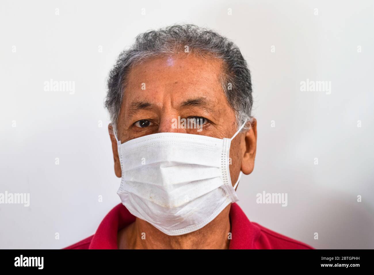 Älterer peruanischer Mann leidet an Husten mit Gesichtsmaske Schutz, älterer Mann mit Gesichtsmaske wegen Luftverschmutzung, kranke ältere Menschen mit medizinischer Maske, Verschmutzung, Stauballergien und Gesundheitskonzept Stockfoto