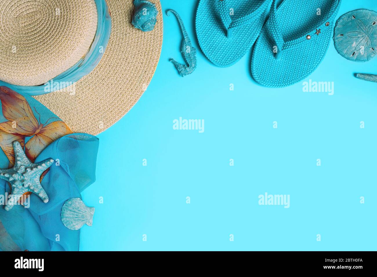 Sommer Mode auf blauem Hintergrund. Flip-Flops, Muscheln und Strohhut mit Schal. Flaches Layout, Draufsicht mit Kopierfläche. Stockfoto