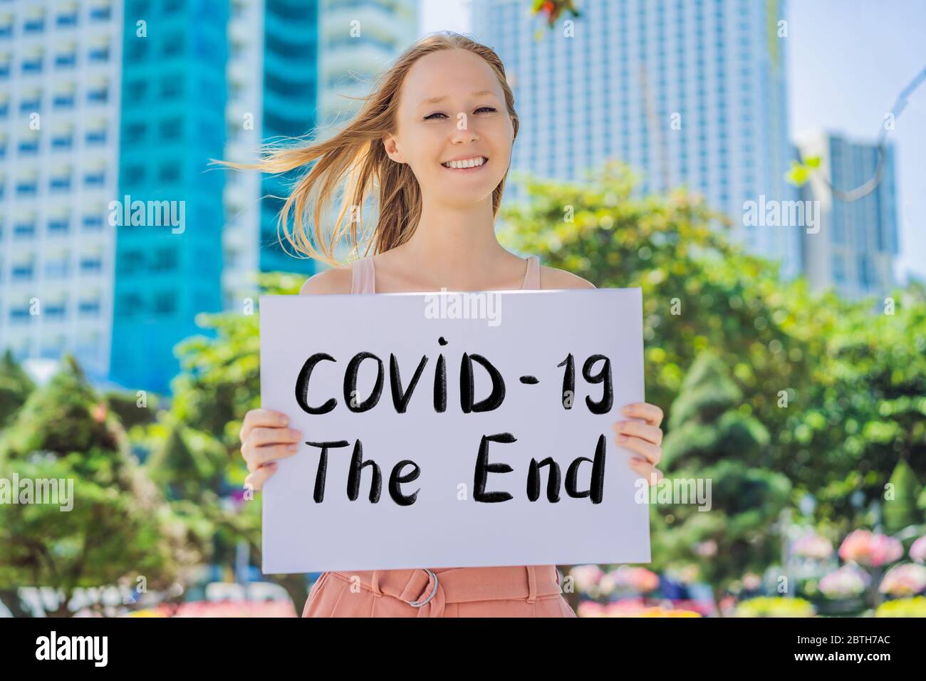 Frau hält ein Plakat COVID 19 das Ende handgeschriebener Text - Schriftzug isoliert auf weiß. Coronovirus COVID 19-Konzept Stockfoto