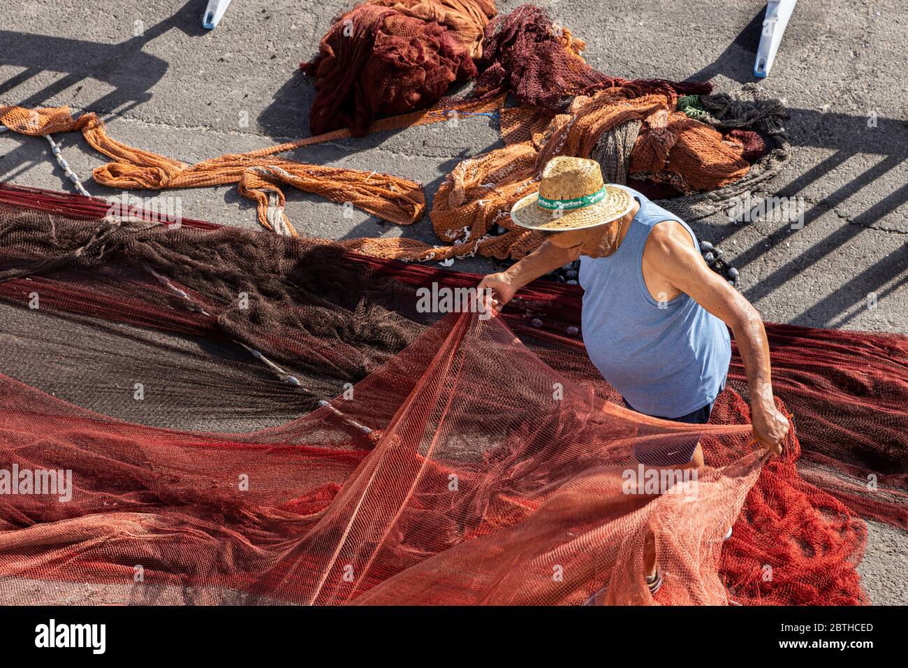Playa San Juan, Teneriffa, Kanarische Inseln, Spanien. 26 Mai 2020. Fischer reparieren ihre Netze am Kai im Fischereihafen an der Westküste. Der Hauptfang in den kanarischen Gewässern ist der Bonito-Thunfisch. Stockfoto