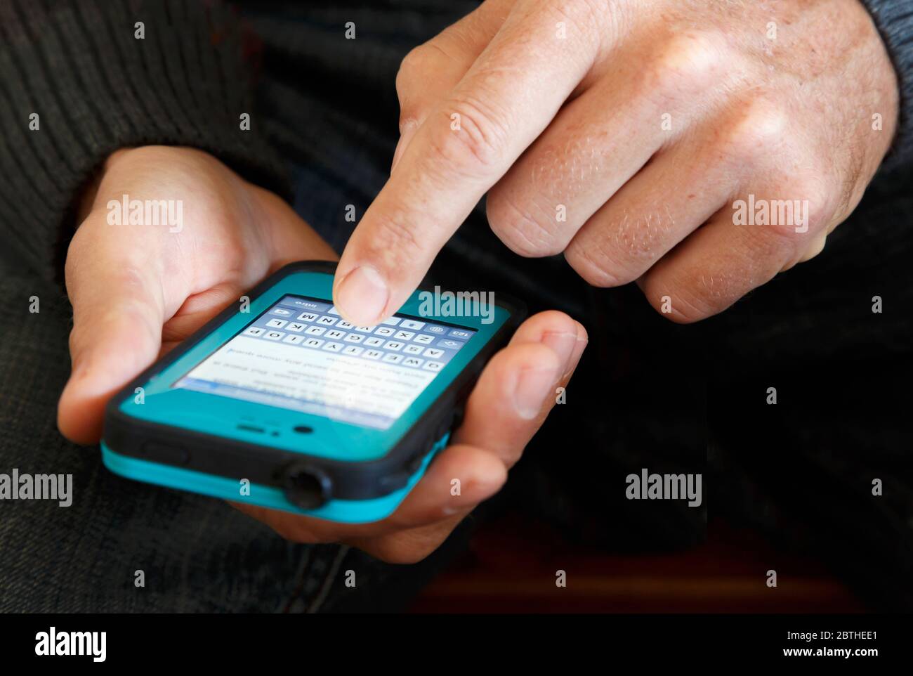 Männliche Hände halten ein Smartphone und tippen in einer Nachricht. Stockfoto