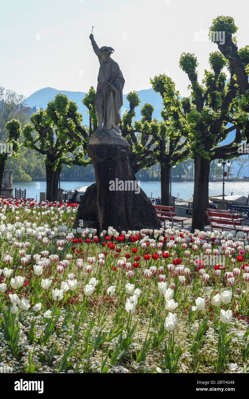 Lugano, Schweiz - 23. April 2020: Öffentlicher Garten mit einer Statue von Wilhelm Tell am Seeufer von Lugano in der Schweiz Stockfoto