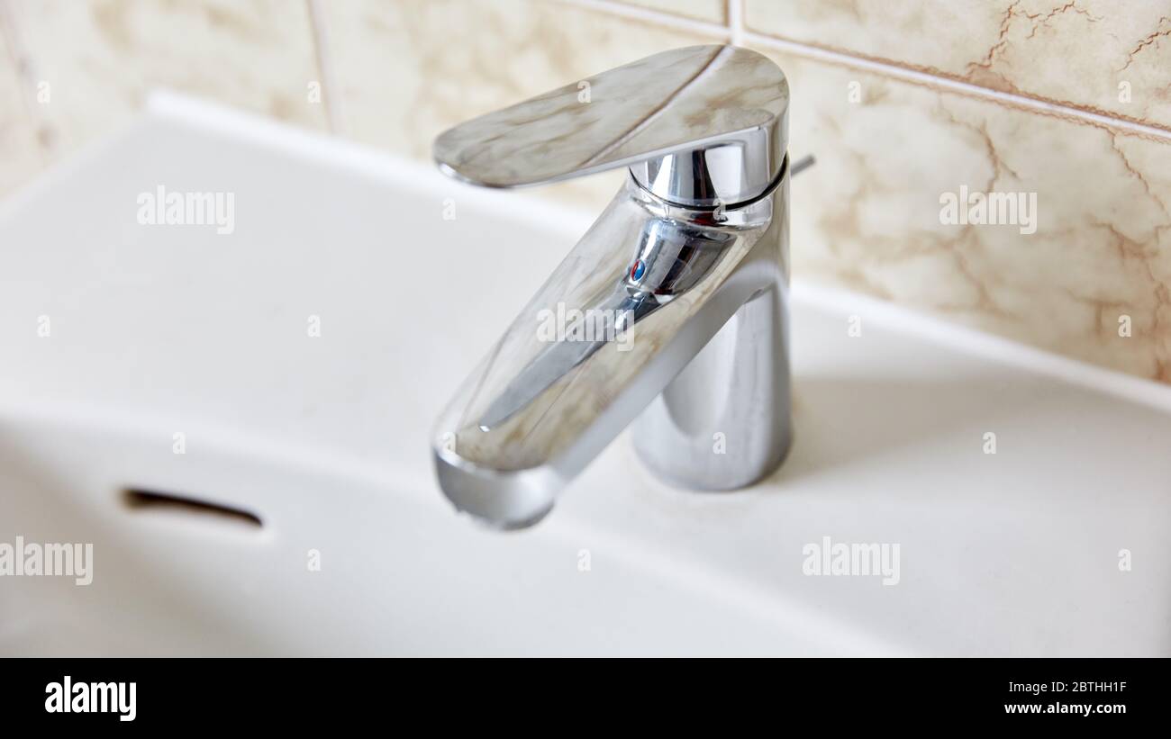 Wasserhahn am Waschbecken im Bad mit Fliesen Stockfoto