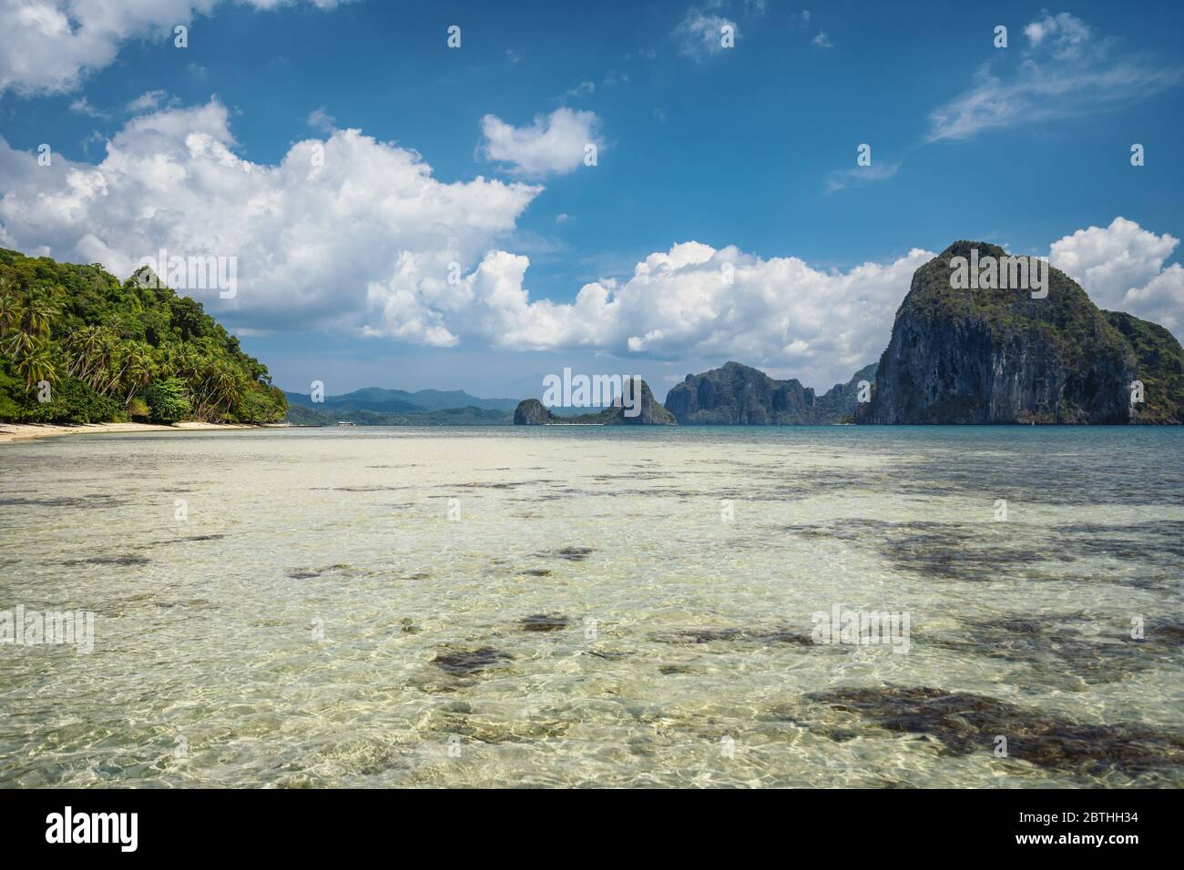 Landschaftlich schöne tropische Landschaft. Flache Lagune, Sandstrand mit Palmen. Exotische Inseln im Hintergrund. El Nido, Palawan, Philippinen Stockfoto