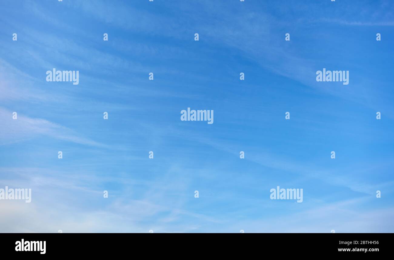 Blauer Himmel am Tag mit wenigen weißen Lichtwolken Stockfoto