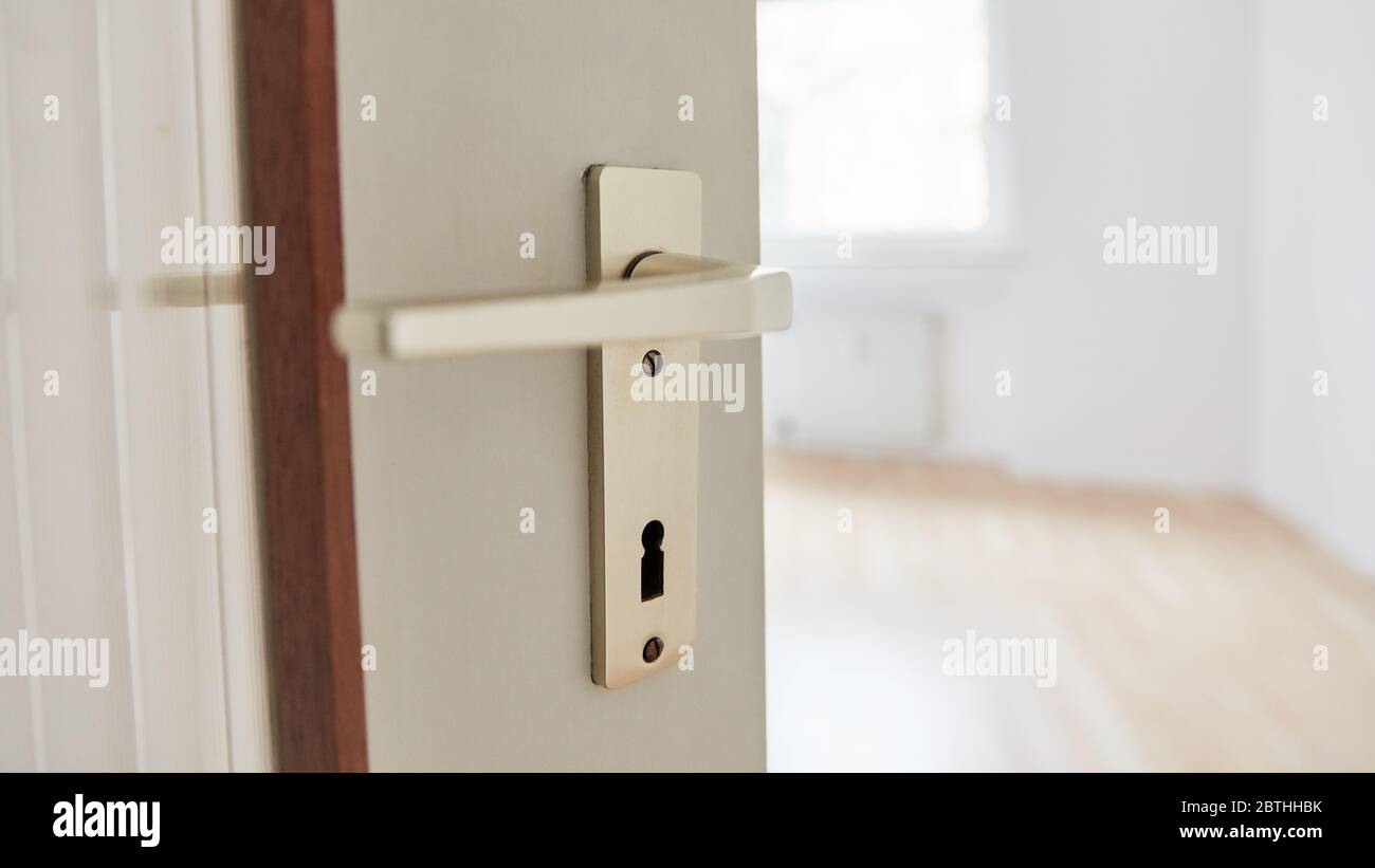 Öffnen Sie die Zimmertür mit einem Griff in einer Wohnung als Umzugskonzept Stockfoto