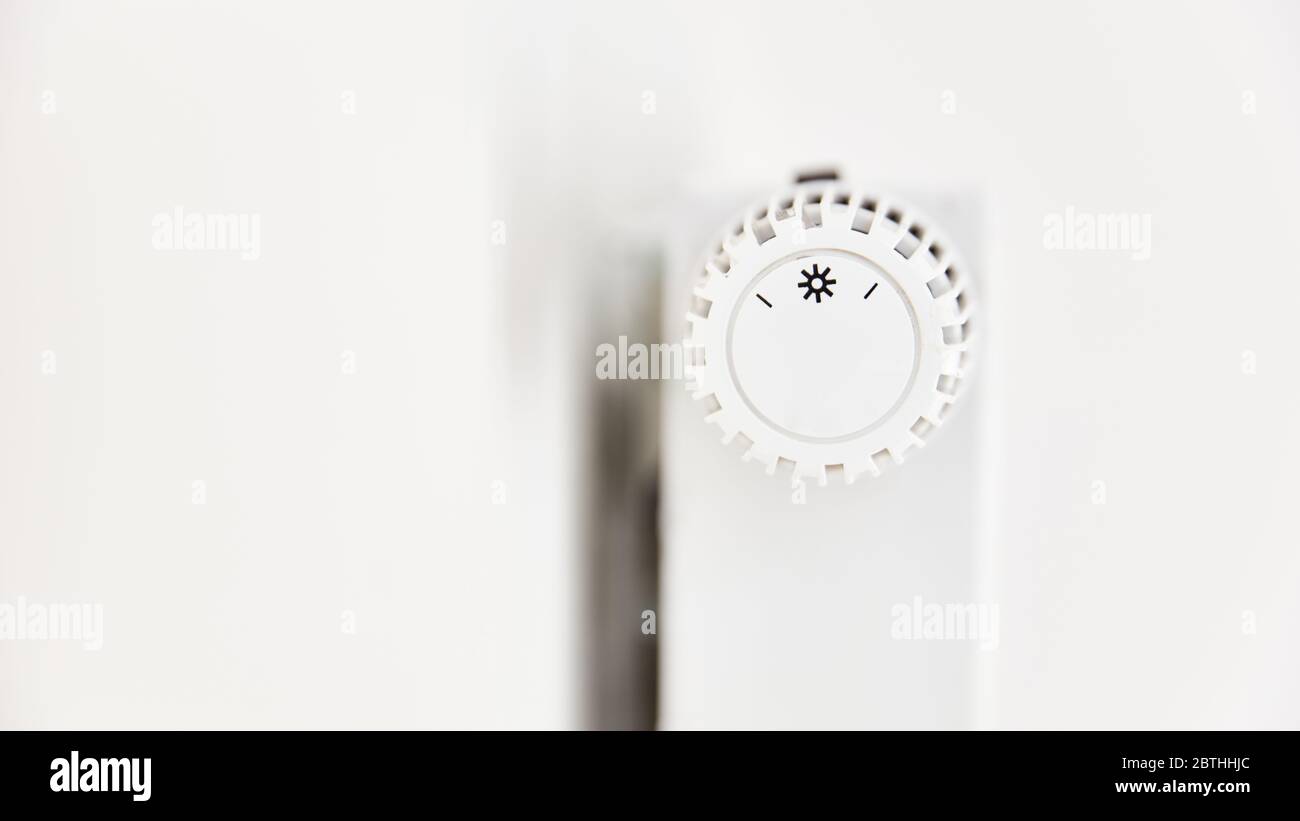 Weißer Thermostat und Temperaturregler auf Heizung mit Heizkörper Stockfoto