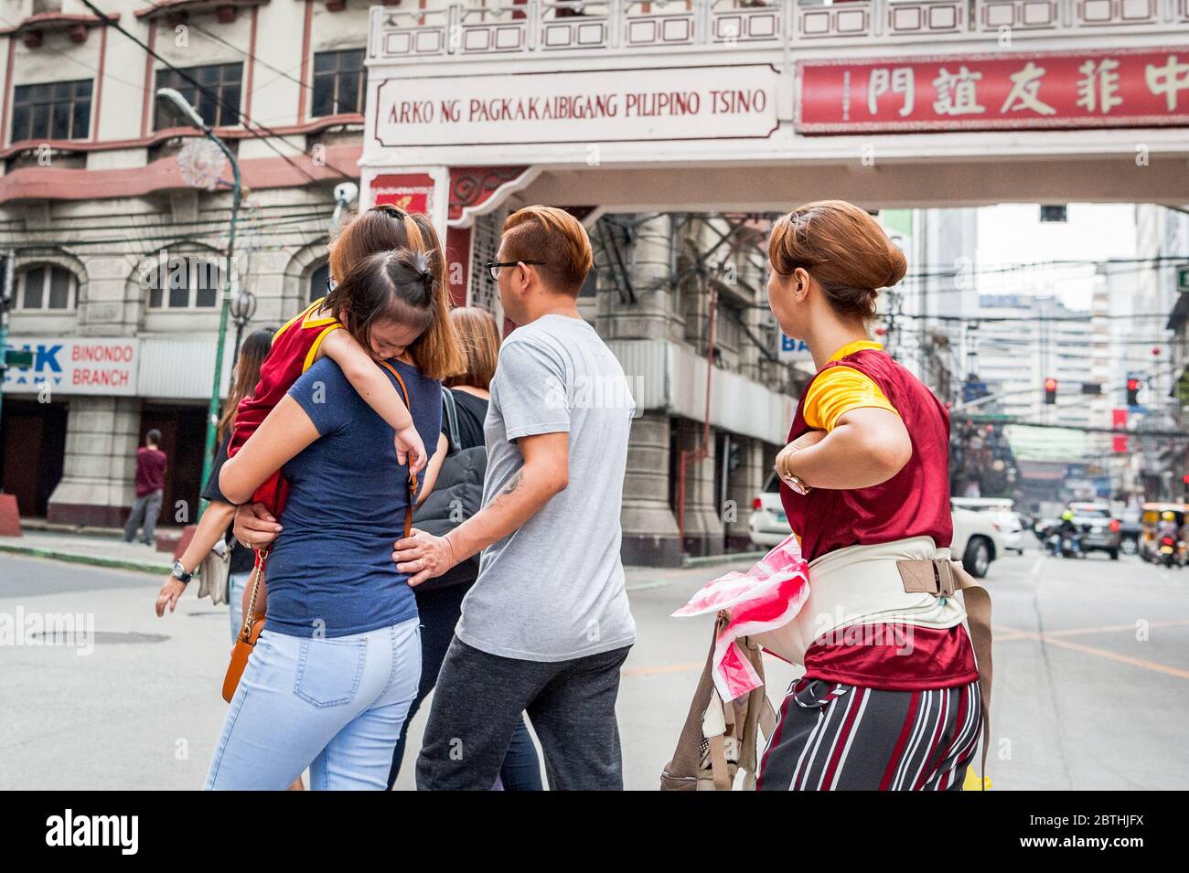 Eine Familie, die das Black Nazarene Festival im philippinischen Chinesischen Freundschaftsbogen im Chinatown Viertel Binondo auf den Philippinen besucht. Stockfoto