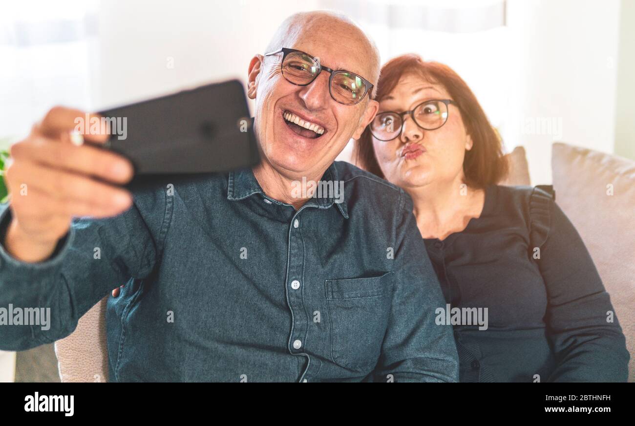Portrait von freudigen älteren verheirateten Paar - Rentner Paar genießen Freizeit machen lustige Selfie - Paar mittleren Alters Spaß zusammen mit smartp Stockfoto