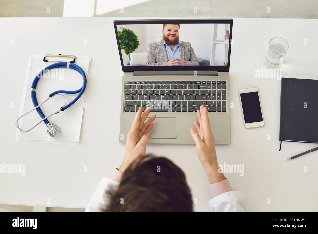 Videoanruf an den Arzt. Männliche Patient hört Arzt mit Laptop-Webcam zu Hause. Stockfoto