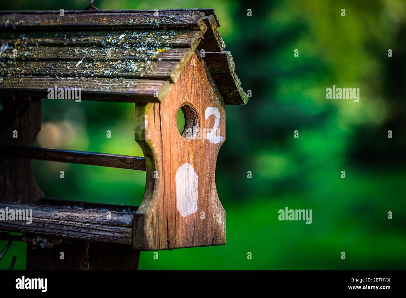 Foto eines Vogelfutterhäuschen, das auf einem Obstbaum in einem Garten steht Stockfoto