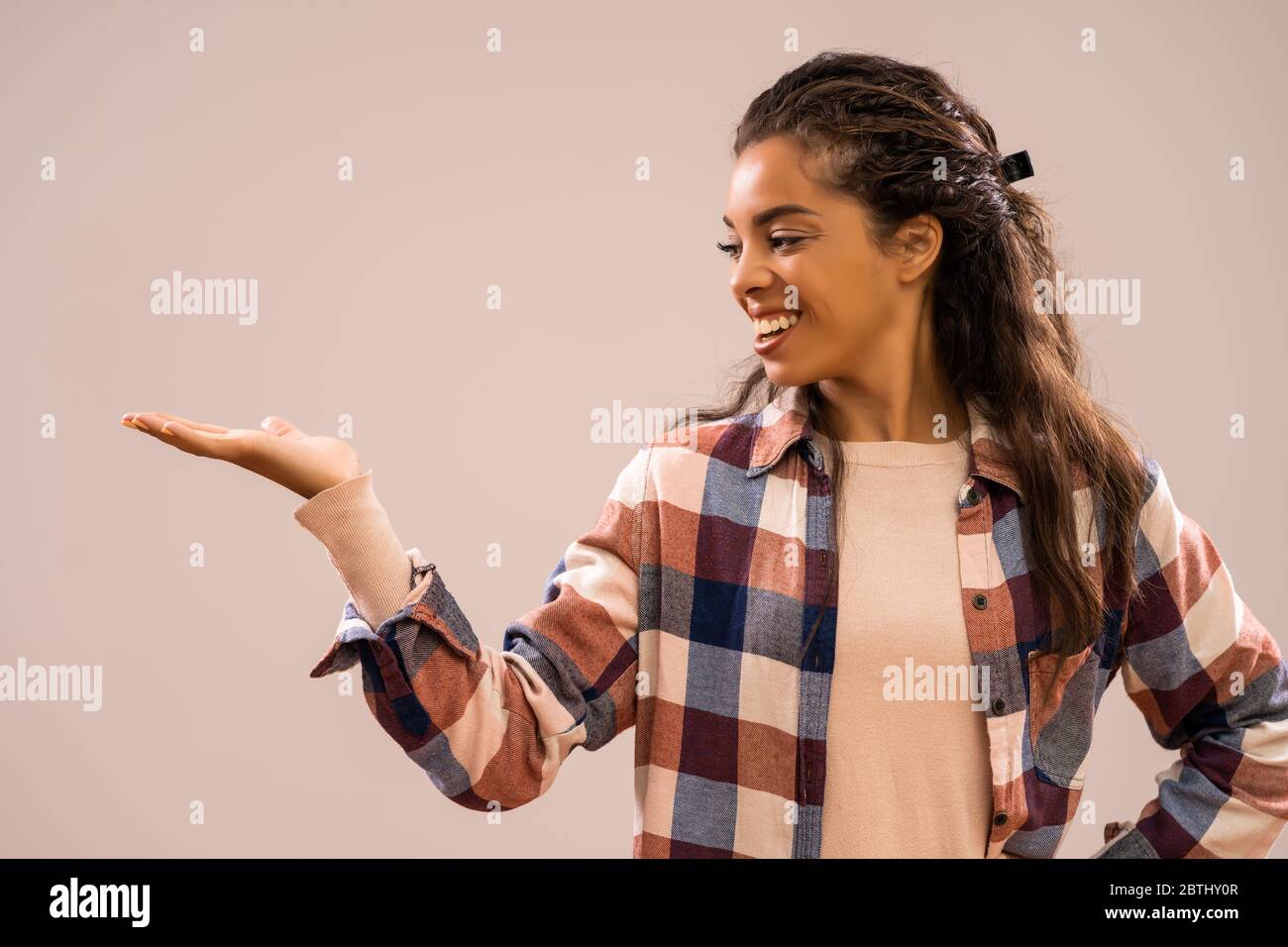 Studio-shot Porträt der schönen glücklichen afroamerikanischen Ethnizität Frau in Freizeitkleidung halten Sie Ihren Text oder Produkt. Stockfoto