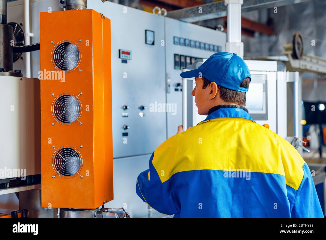 Mann Arbeiter in der Produktionsanlage bei Kabel Fabrik Maschine Control Computer Panel Stockfoto