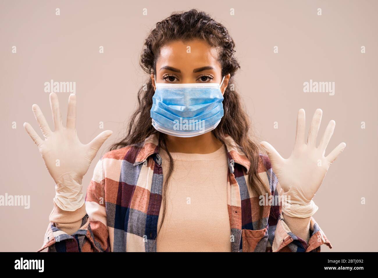 Studio-Shot Porträt der schönen afroamerikanischen Ethnie Frau, die Schutzmaske und Handschuhe trägt. Stockfoto