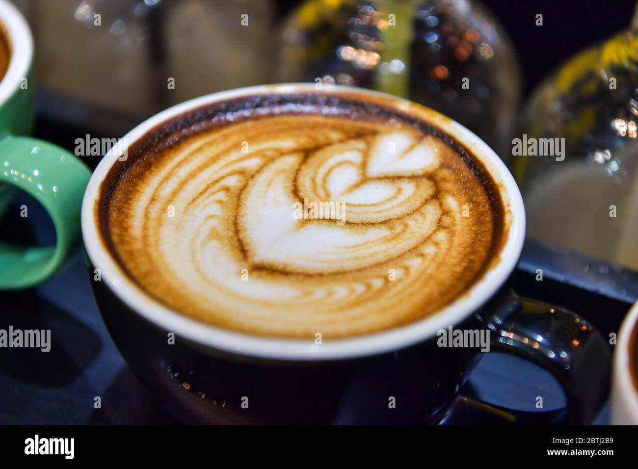 Formen von Kunst-Kaffee auf grünen Tassen. Stockfoto