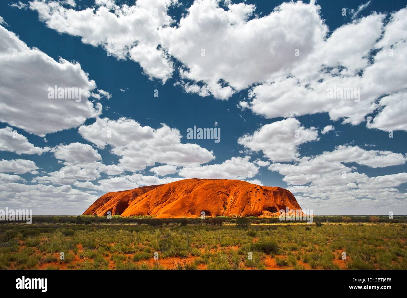 Majestätischer Uluru in roter Wüstenebene. Stockfoto