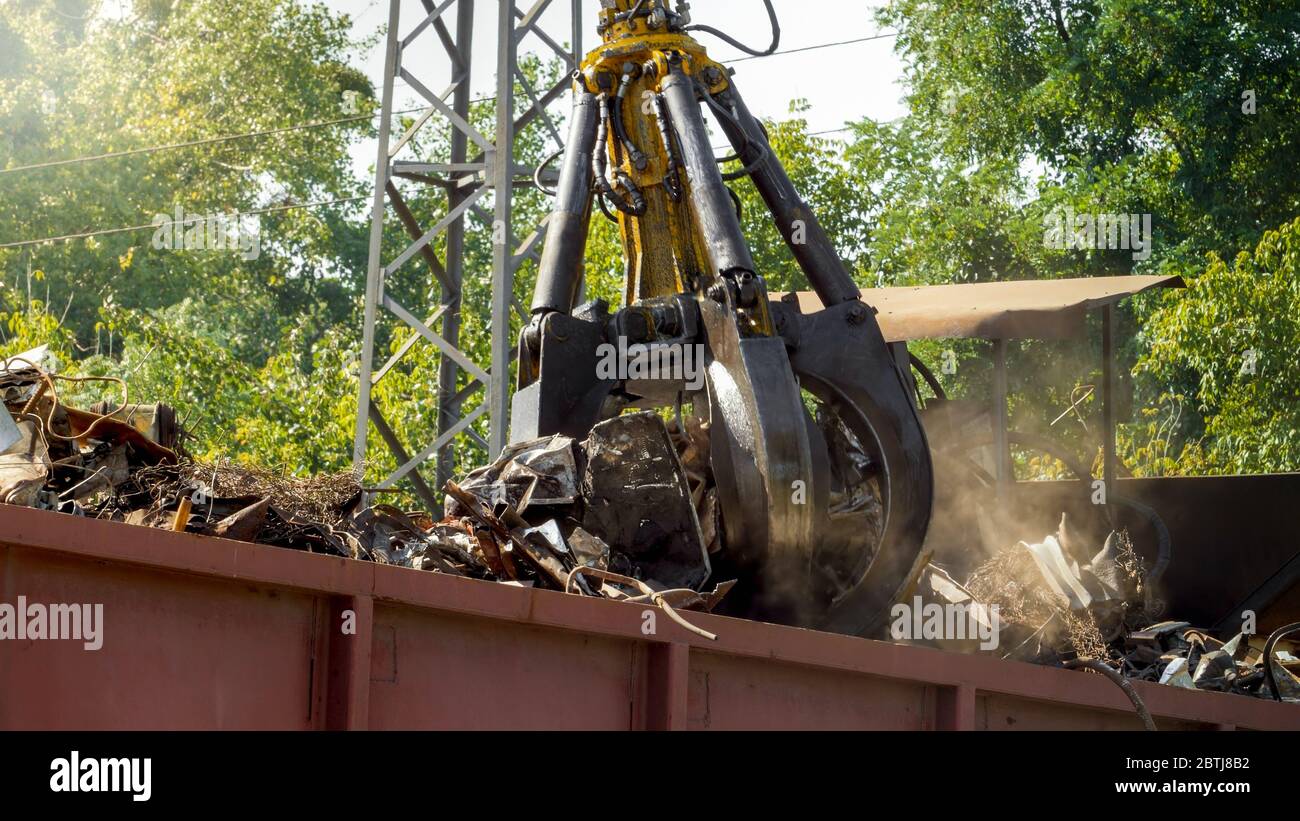 Bild von Metallgreifer Zerkleinern und Zerstören von alten Metallteilen auf Schrottplatz Stockfoto