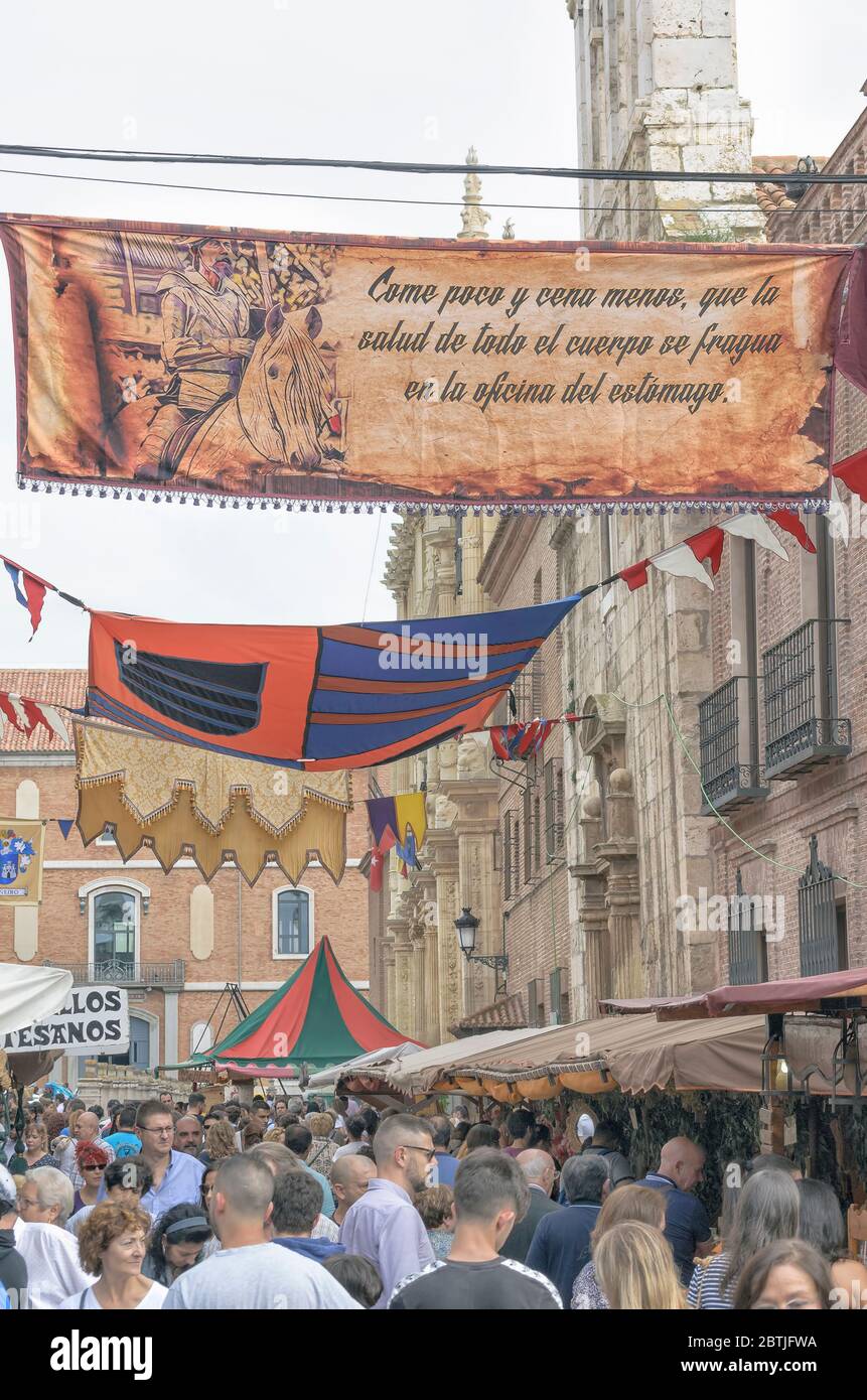 Banner mit Text aus dem Buch 'El ingenioso hidalgo don Quijote de la Mancha' von Miguel de Cervantes. Leute am San Diego Platz. Alcala de Henares .Spanien Stockfoto