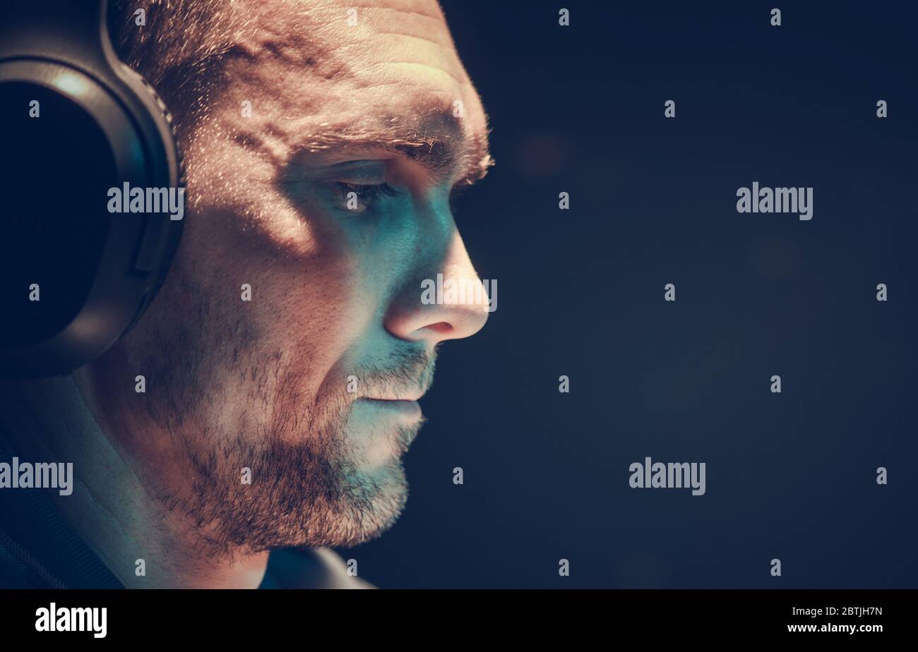 Kaukasische zufriedene Männer in seinen 30er Jahren tragen große moderne kabellose Kopfhörer. Drahtlose Audioübertragung. Thema „Songs Listening“. Stockfoto