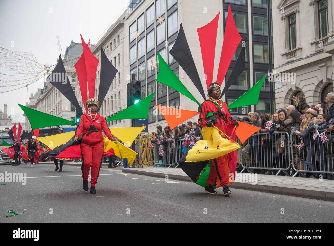 London Neujahrsparade 2020, Frau in großen roten, grünen und gelben Karnevalskostümen. Stockfoto