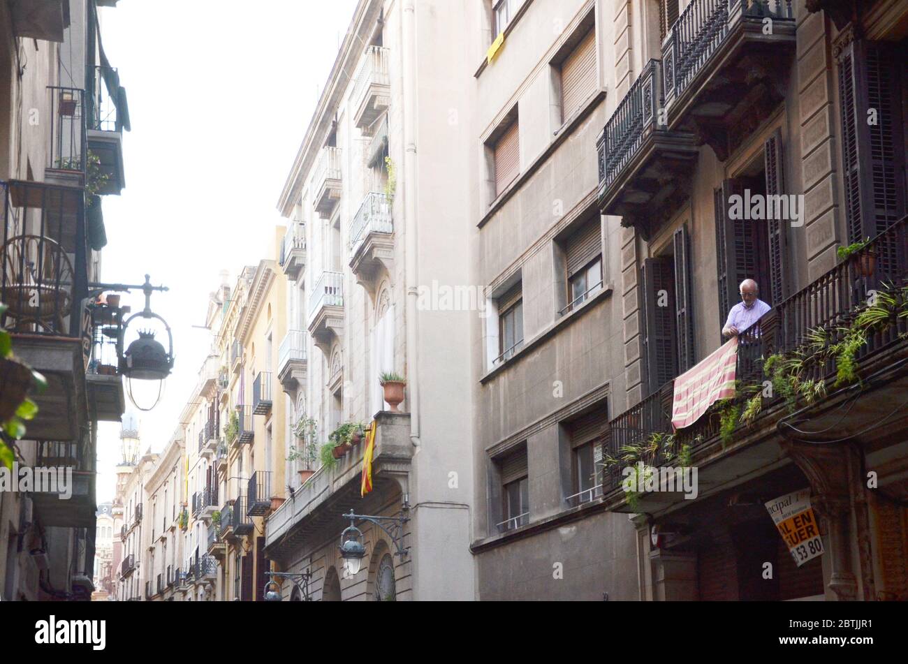 Ein Mann, der an der Seite des Balkons in der Straße von La rambla steht. Stockfoto