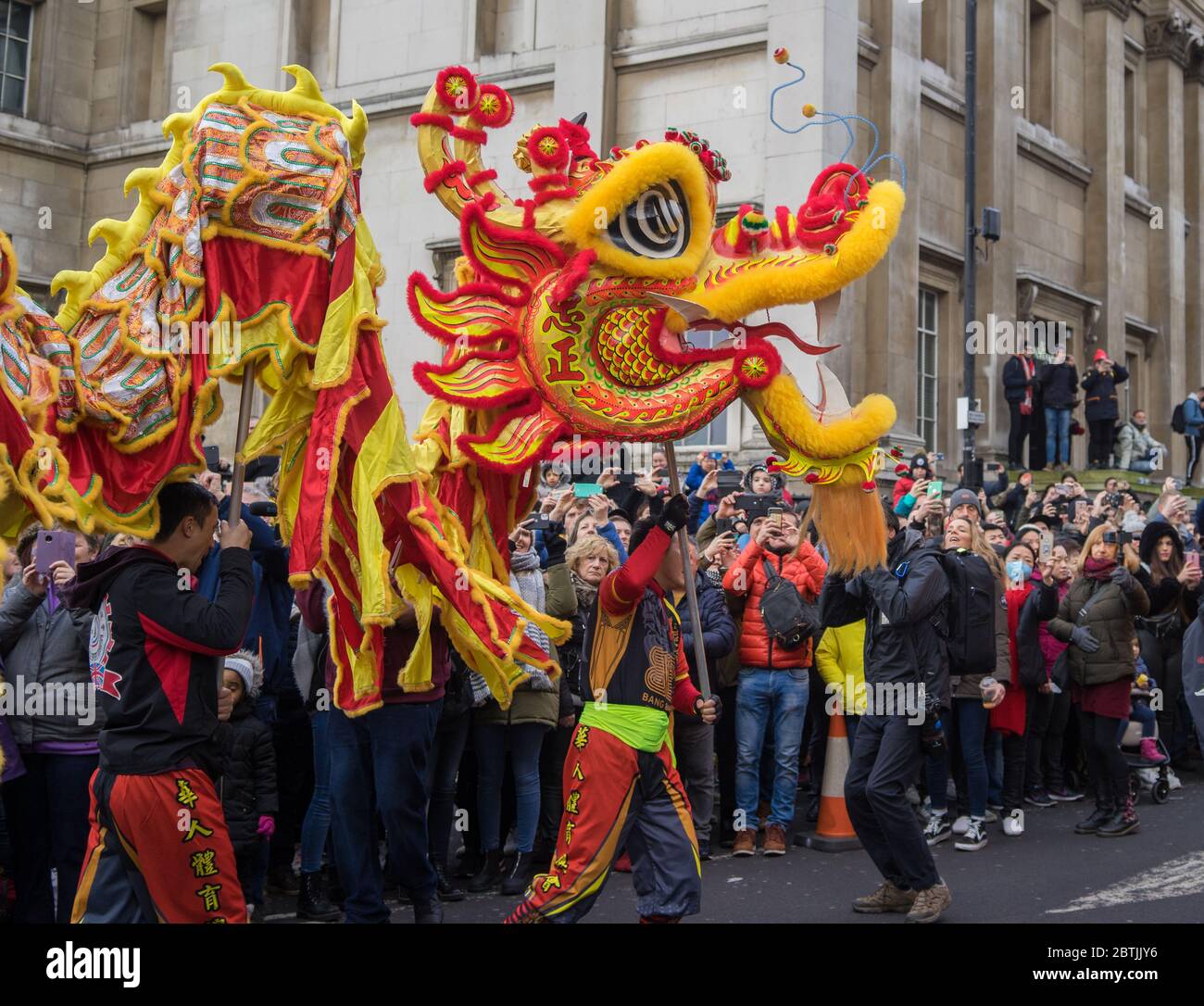 Rot und gelb chinesischer Drache, der seinen Weg durch die Parade der chinesischen Neujahrsfeier macht. London Stockfoto