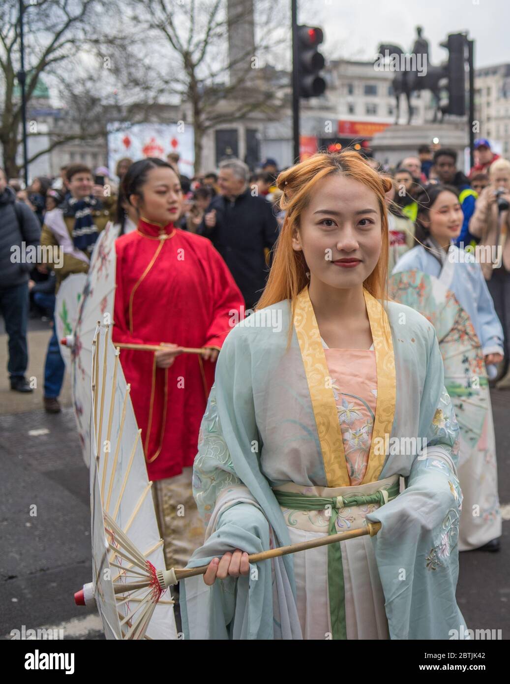 Hübsche Dame mit roten Haaren in traditionellem chinesischen Kleid mit Regenschirm. Parade Zur Chinesischen Neujahrsfeier. London Stockfoto