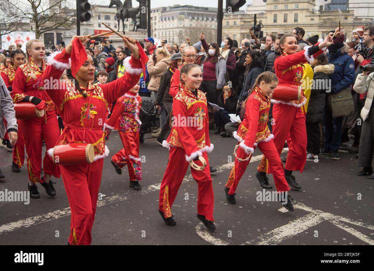 Jugendliche in roten Kostümen mit Schlaginstrumenten bei der Parade zur chinesischen Neujahrsfeier. London Stockfoto